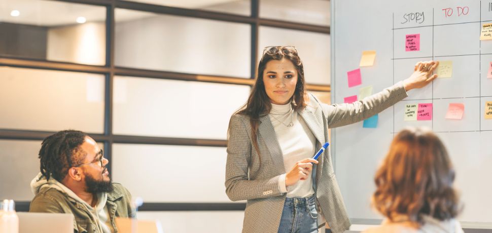 Photo illustrant une dirigeante en train de montrer les étapes d'un projet - gestion de projet